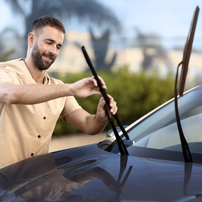 man-replace-windshield-wipers-on-car-standing-outd-2023-11-27-04-49-30-utc